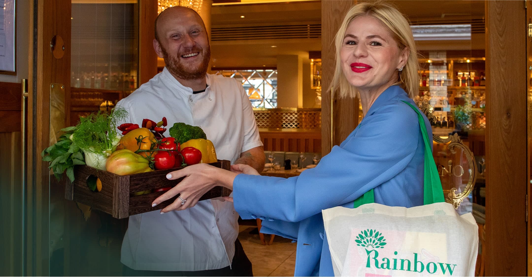 Chef and customer exchanging fresh produce at Rainbow